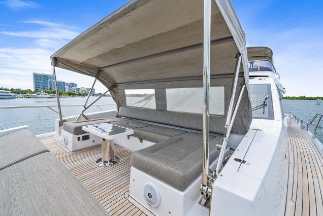 72ft Azimut “Water You Doing” luxury yacht available for charter in Miami with VIP seating area at the bow with shaded cover.,