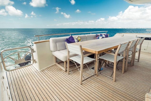 Luxury 110ft Dominator Senay Miami grand boarding entrance with access to the upper deck with spacious table with chairs.