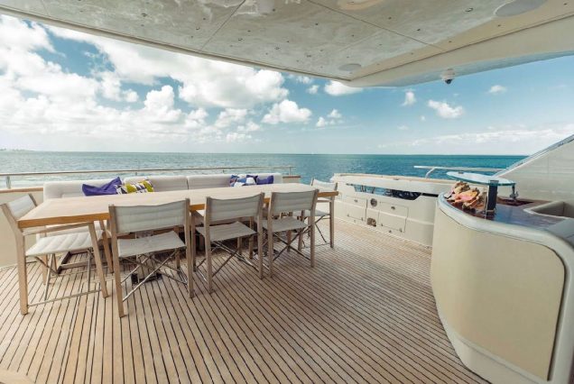 Luxury 110ft Dominator Senay Miami grand boarding entrance with access to the upper deck with spacious table with chairs.