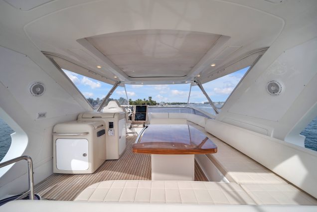 Luxury 64ft Deon Miami upper deck seating with table for cocktails and fine dining