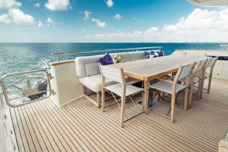 Luxury 110ft Dominator Senay Miami grand boarding entrance with access to the upper deck with spacious table with chairs.
