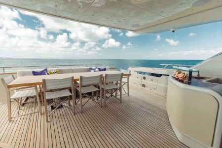 Luxury 110ft Dominator Senay Miami grand boarding entrance with access to the upper deck with spacious table with chairs.